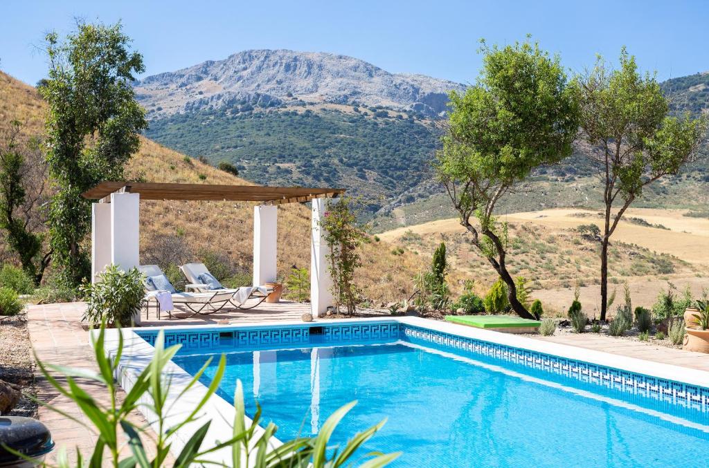 a swimming pool with a mountain in the background at Finca Águilar in Colmenar