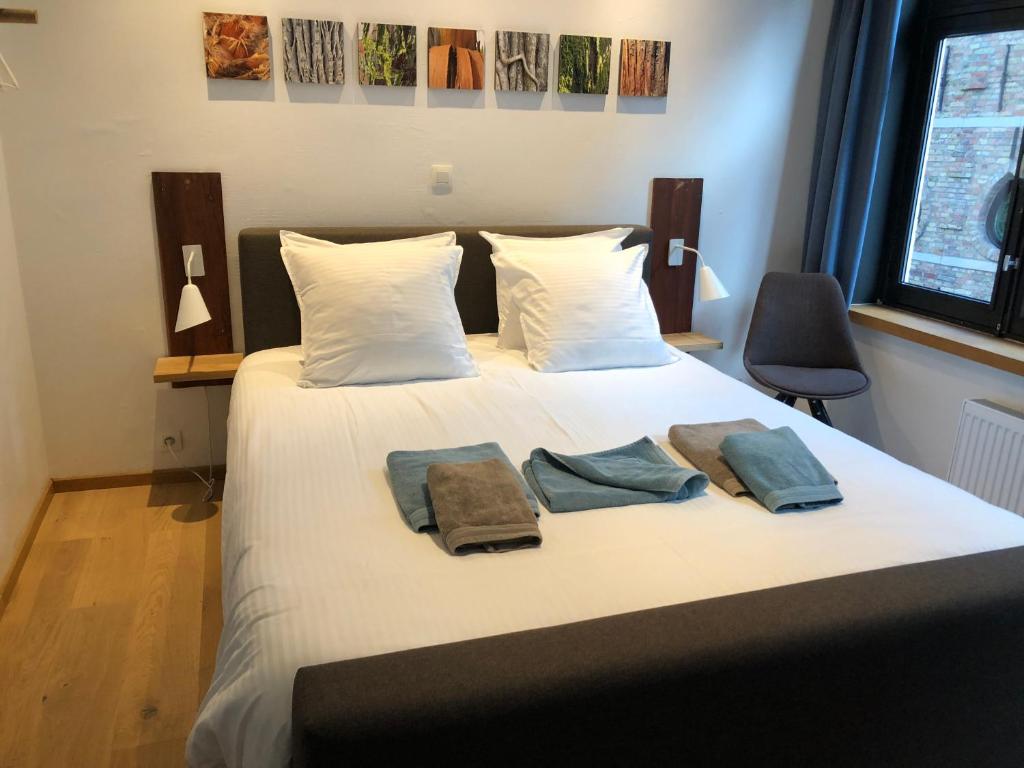 een slaapkamer met een bed met twee handdoeken erop bij B&B Calis in Brugge