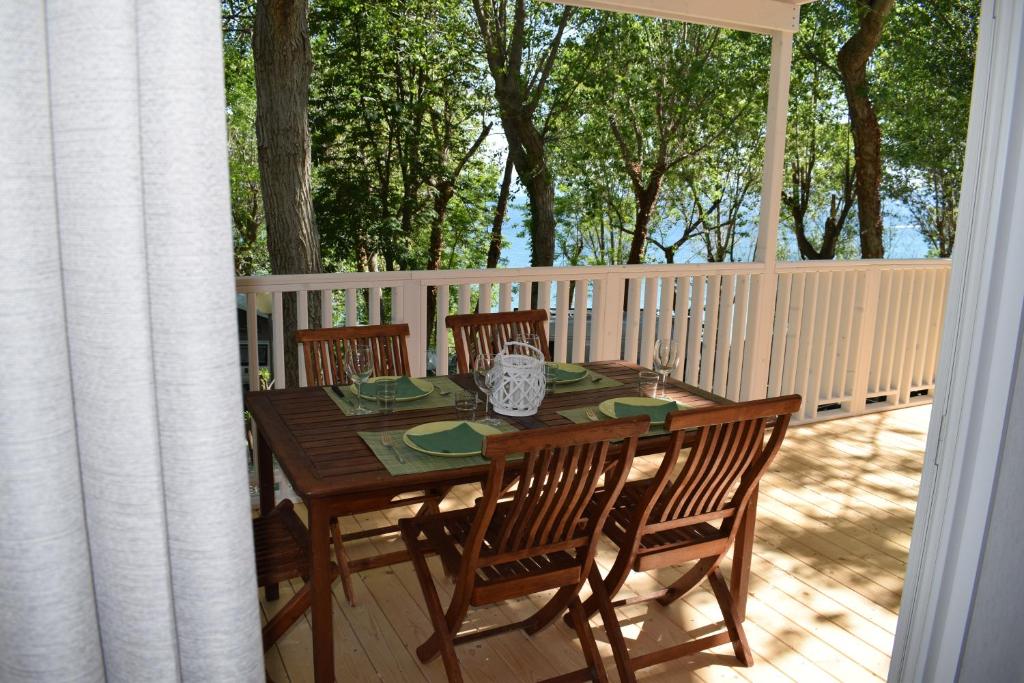 un tavolo e sedie in legno su una terrazza di Camping Gabicce Monte a Gabicce Mare