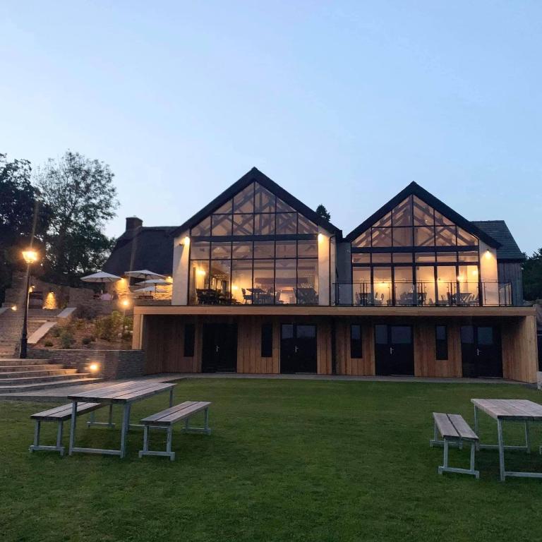 a building with benches in the grass in front of it at The Old House 1147 in Bridgend