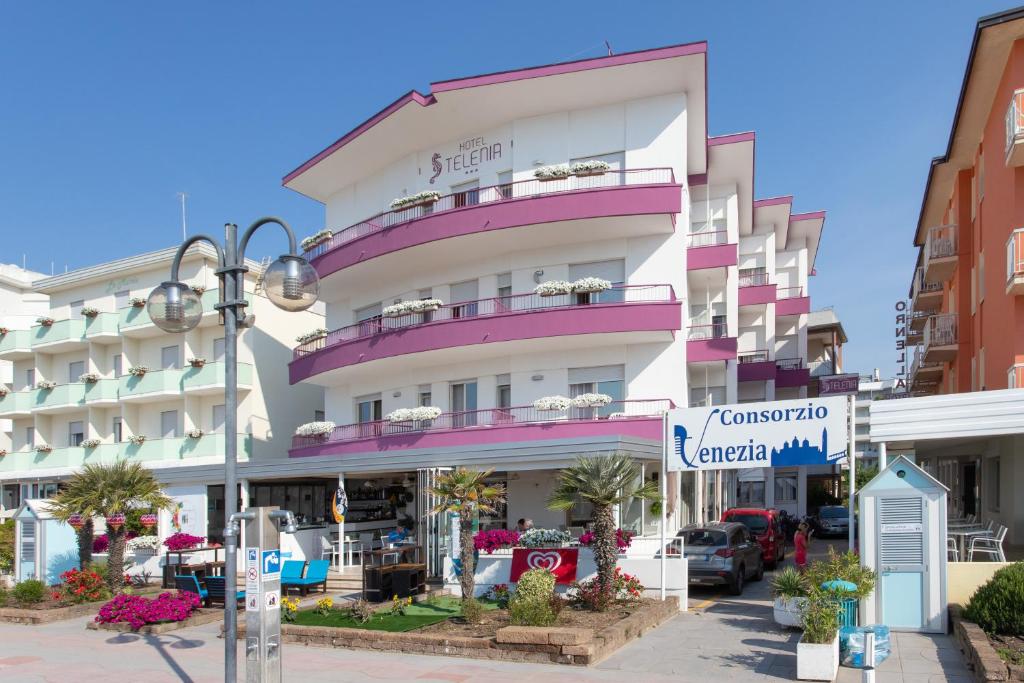 a pink and white building on a city street at Hotel Telenia in Lido di Jesolo