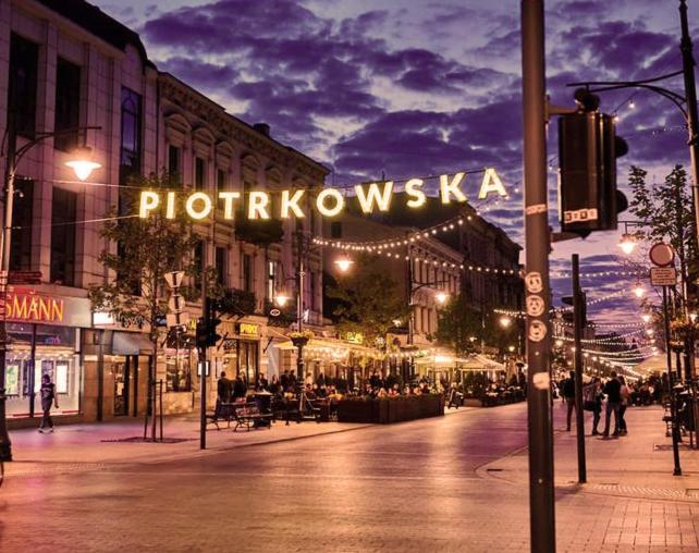 罗兹Apartament I LOVE PIOTRKOWSKA z wielkim lustrem, balkonem i klimatyzacją的夜间的城市街道,标有读书的标牌