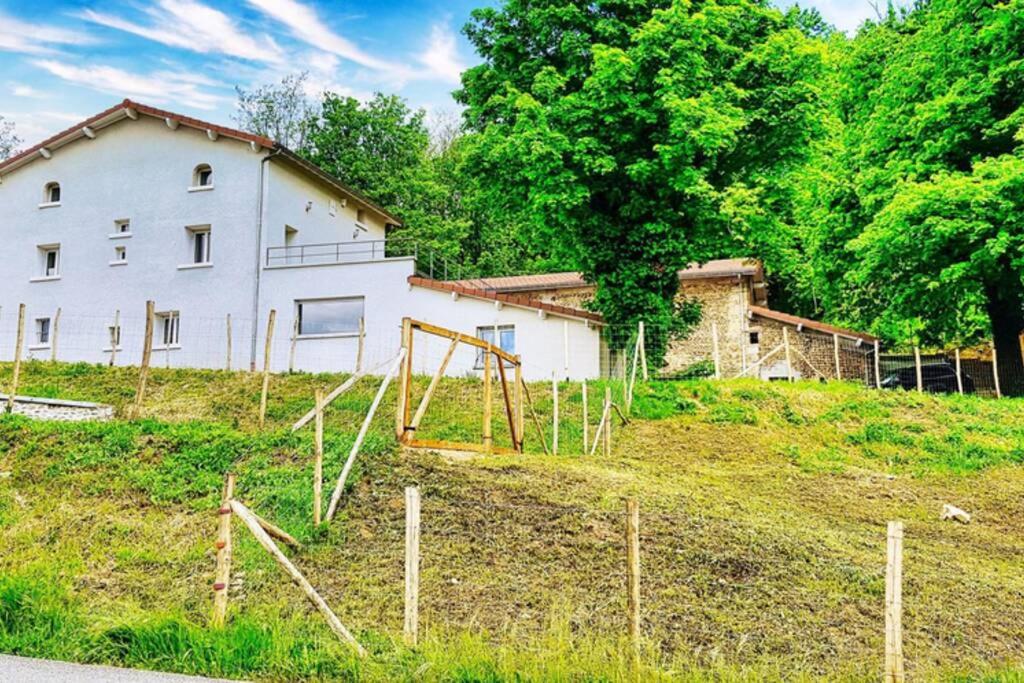 una casa en una colina con un patio de juegos delante de ella en Villa complète au calme avec vue imprenable, en Beausemblant