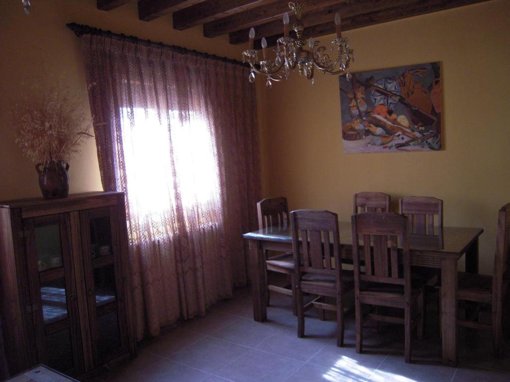comedor con mesa, sillas y ventana en Casa Rural Carmina, en Berlanga de Duero