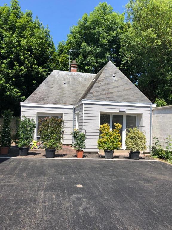 a white house with potted plants in front of it at Dar Lila Cote d'Opale in Saint-Martin-Boulogne