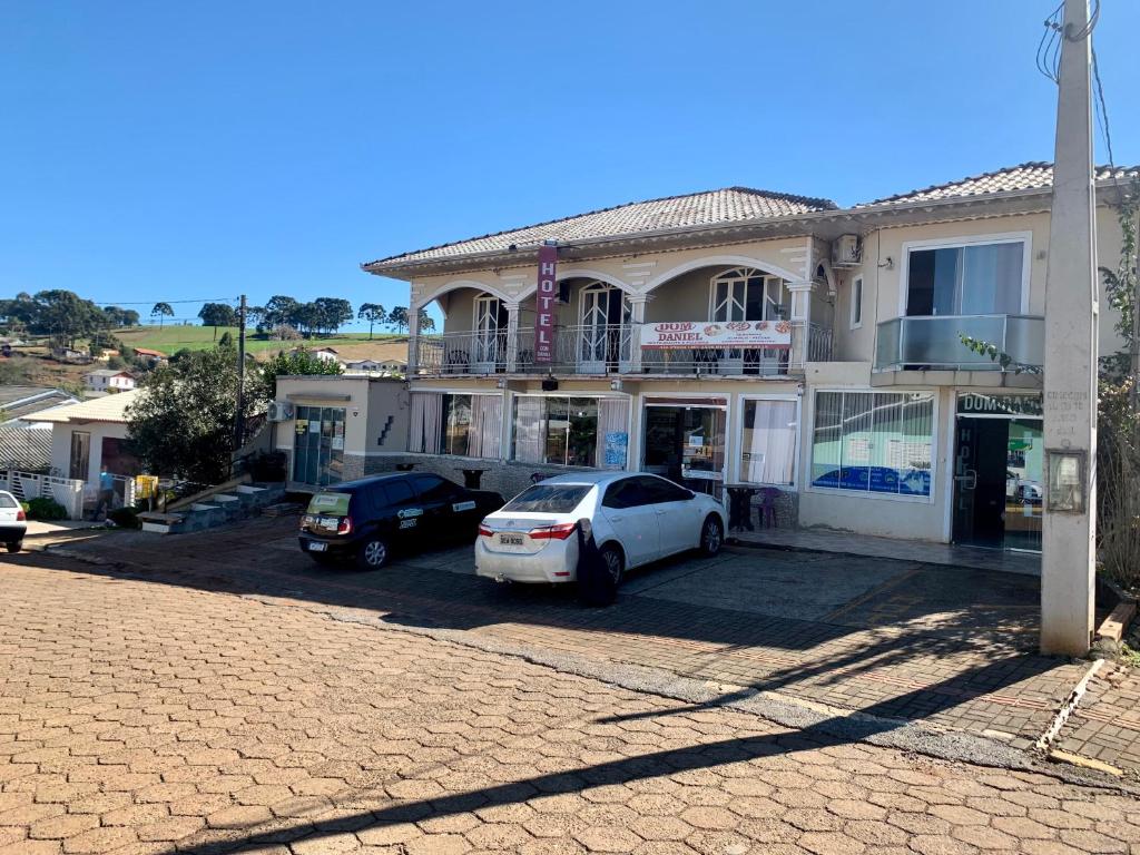 PalmaresHotel Dom Daniel的两辆汽车停在房子前面