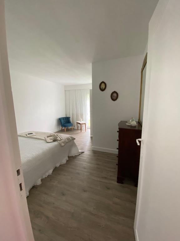 a bedroom with a bed and a wooden floor at LE VIEUX MOULIN in Bouhet