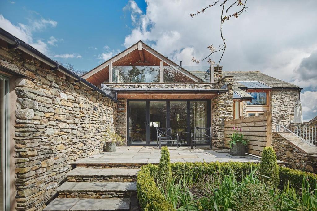 a stone house with a patio in front of it at Shepherd's View in Kendal