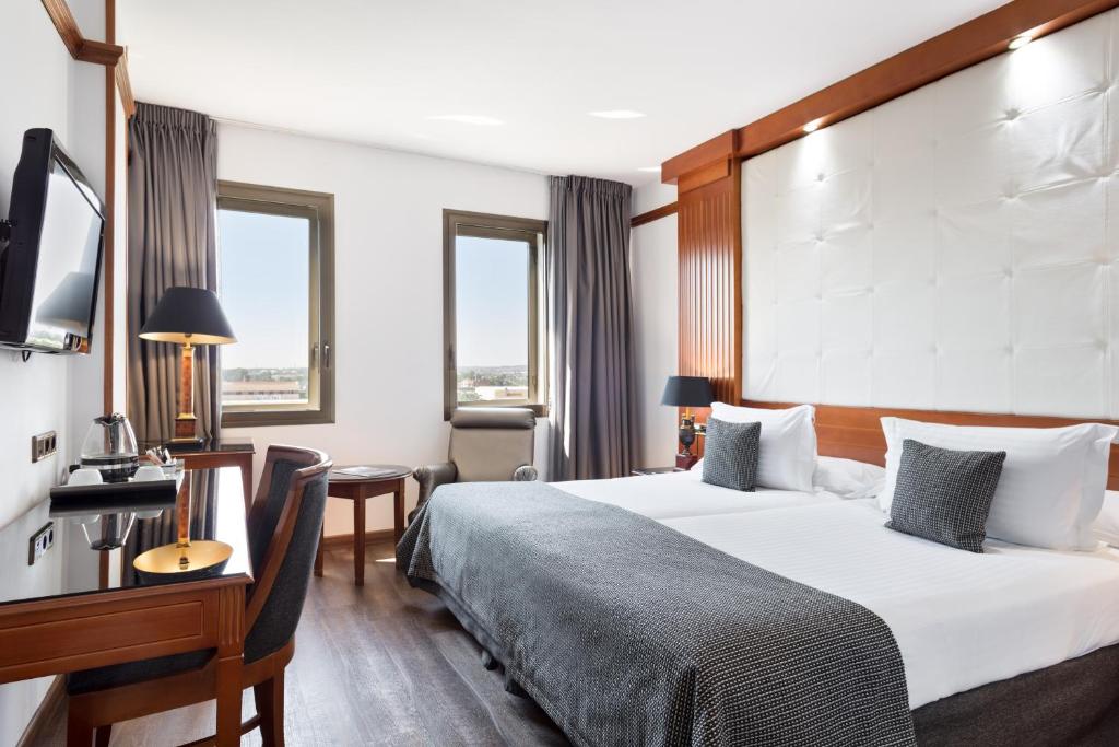 a hotel room with a large bed and a large window at Hotel CMC Girona in Girona