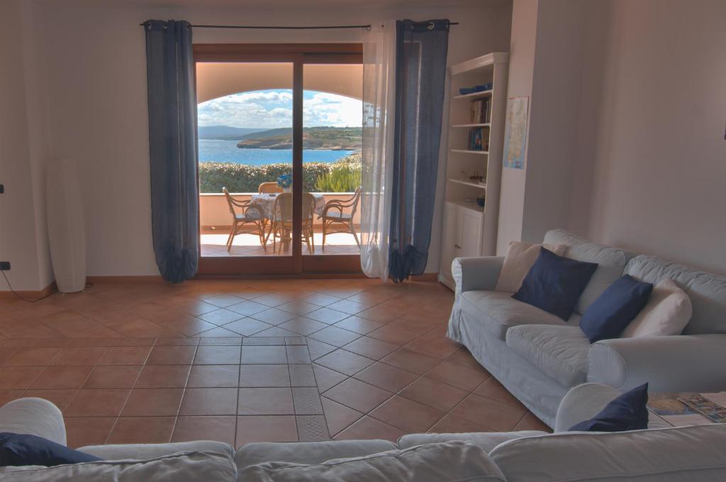 un soggiorno con divano e vista sull'oceano di L'Ancora Blu a Porto Torres