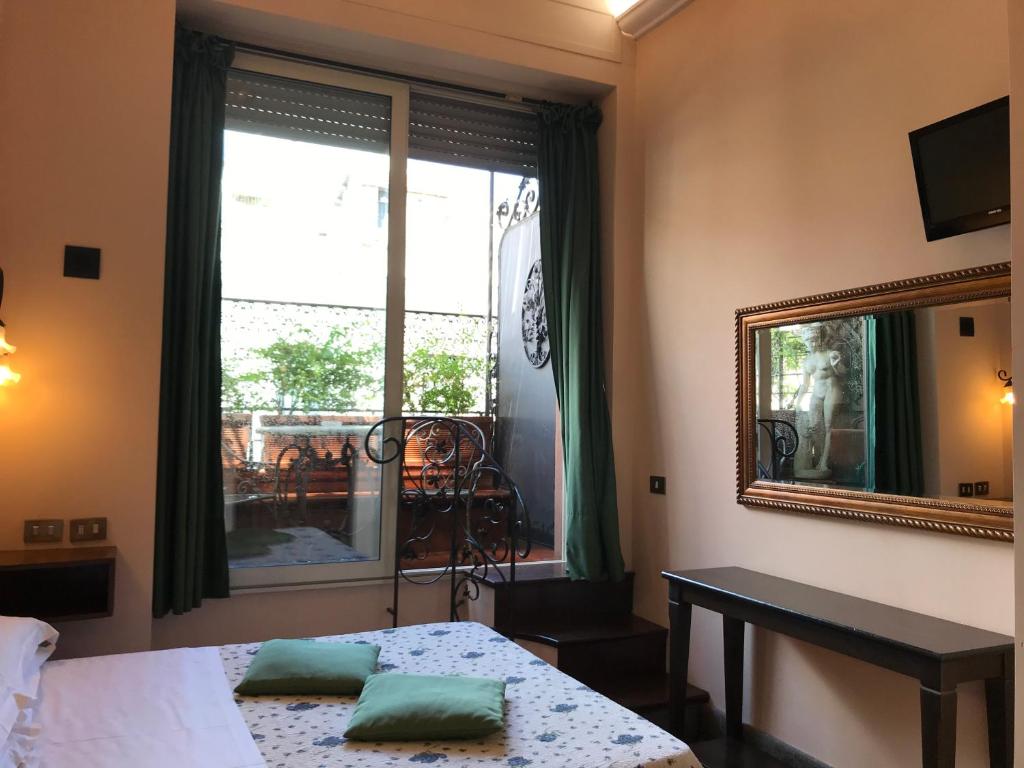 a bedroom with a bed and a mirror and a window at Hotel OKAPI in Rome