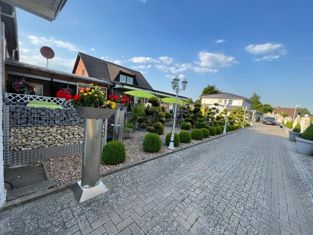 a cobblestone street with flowers in a yard at Pension Cao Lai in Varel