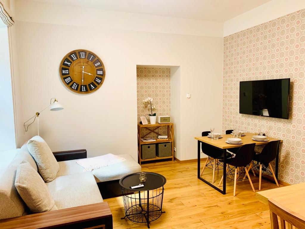 a living room with a couch and a clock on the wall at Lossi 32 Apartment in Tartu