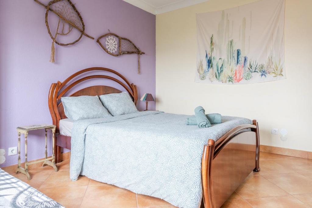 a bedroom with a bed with a wooden head board at Natural Mystic Hostel in Costa da Caparica