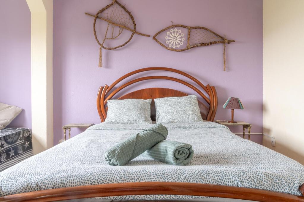 a bedroom with a large bed with purple walls at Natural Mystic Hostel in Costa da Caparica