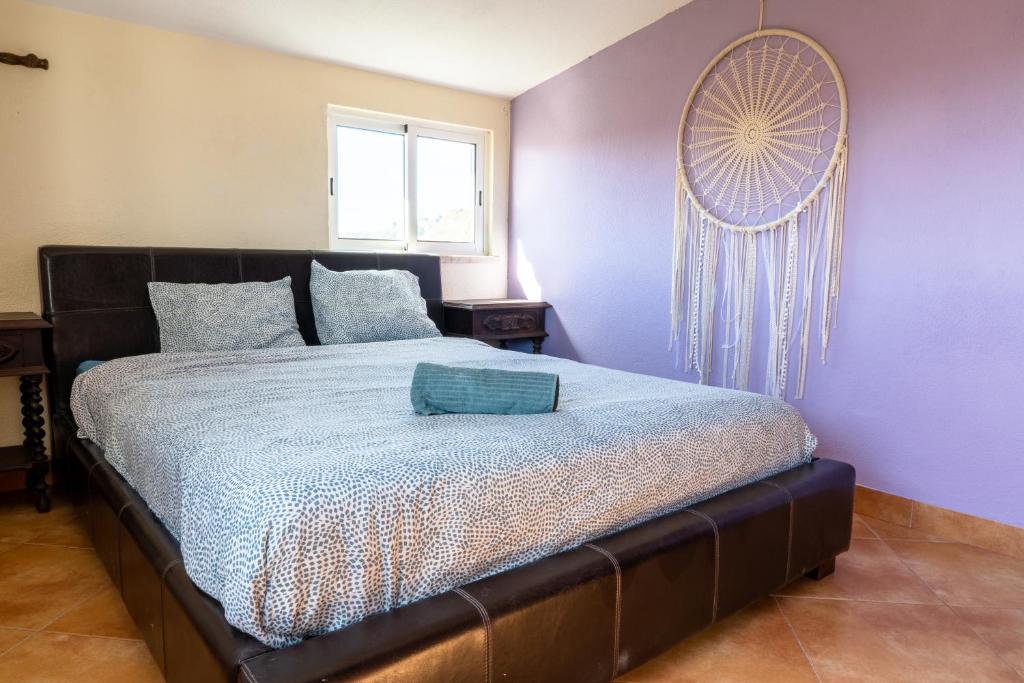 a bedroom with a large bed with purple walls at Natural Mystic Hostel in Costa da Caparica