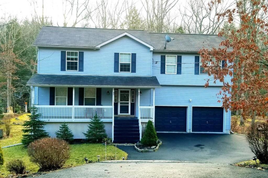 a blue house with a driveway at *Amenity-Filled Waterfront Oasis @Saw Creek Estates Near WaterFalls and Hiking* in East Stroudsburg