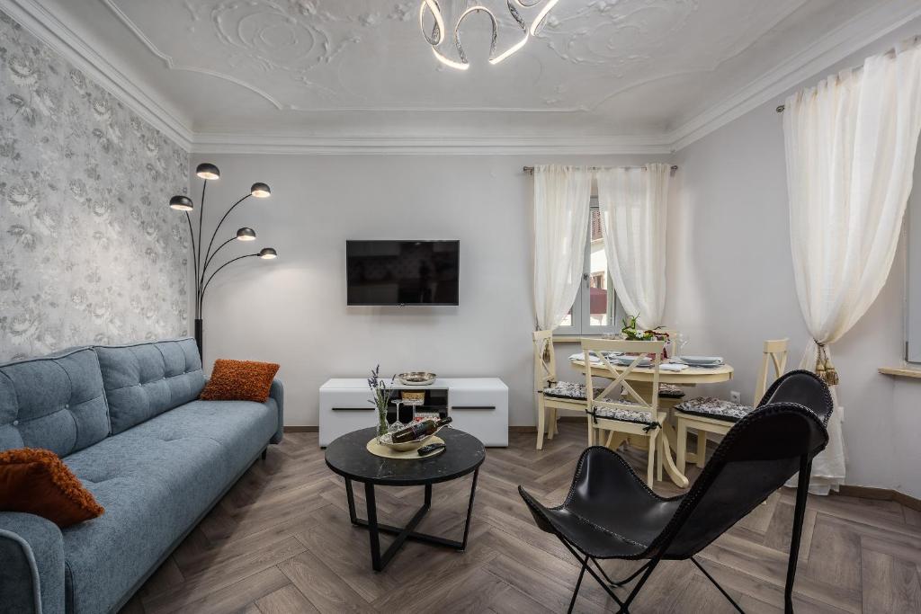 sala de estar con sofá azul y mesa en Premium Apartment Daka, en Poreč