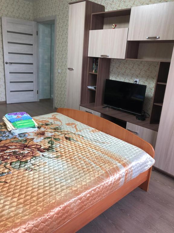 a large bed in a room with a tv at Уютная 2 -х комнатная квартира в центре Кеми in Kem