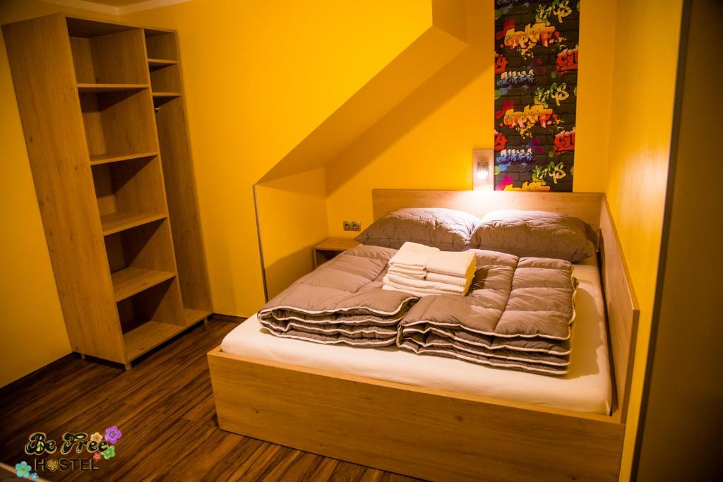 a bed in a room with a yellow wall at BeFree Hostel - Self-Service in Vienna