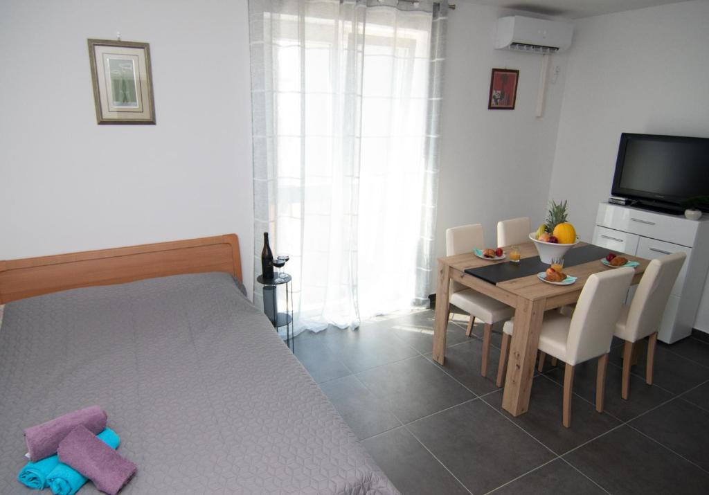 Valkane beach studio apartment في بولا: غرفة معيشة مع طاولة وغرفة طعام