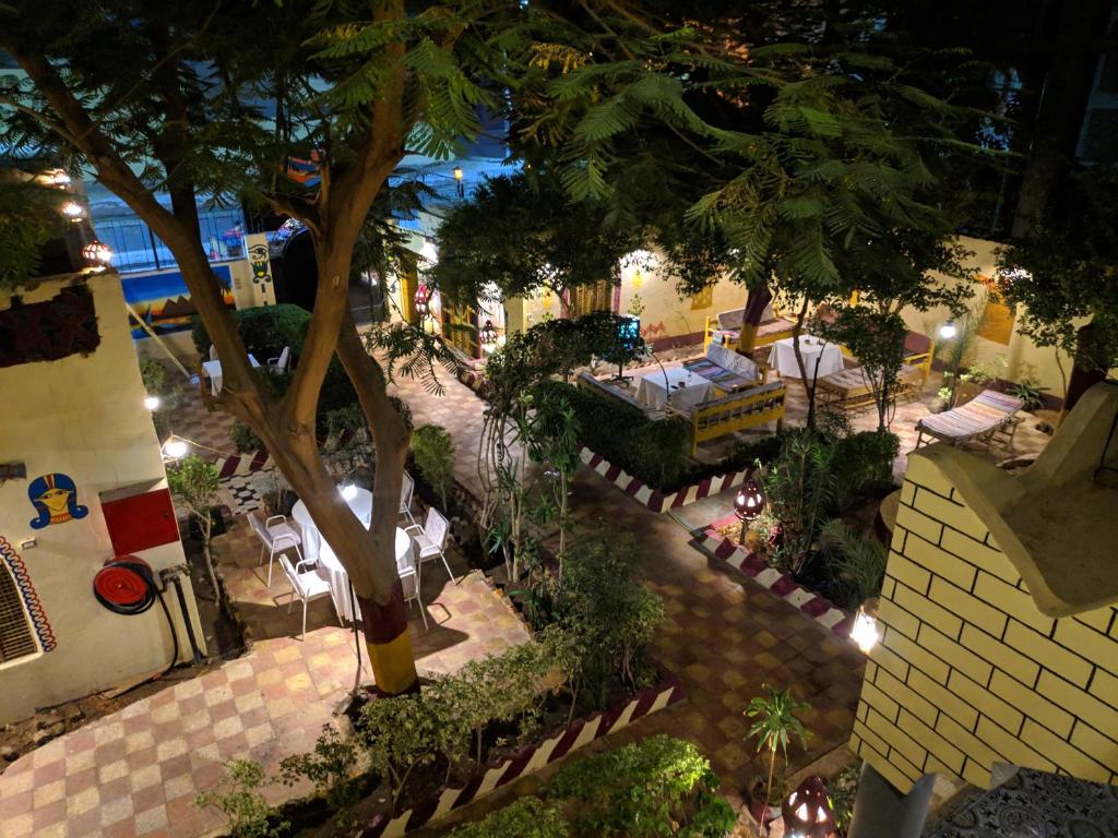 een patio met stoelen en bomen bij Elphardous Hotel in Luxor