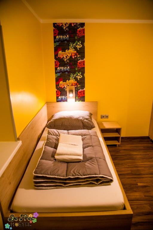 a large bed in a room with yellow walls at BeFree Hostel - Self-Service in Vienna