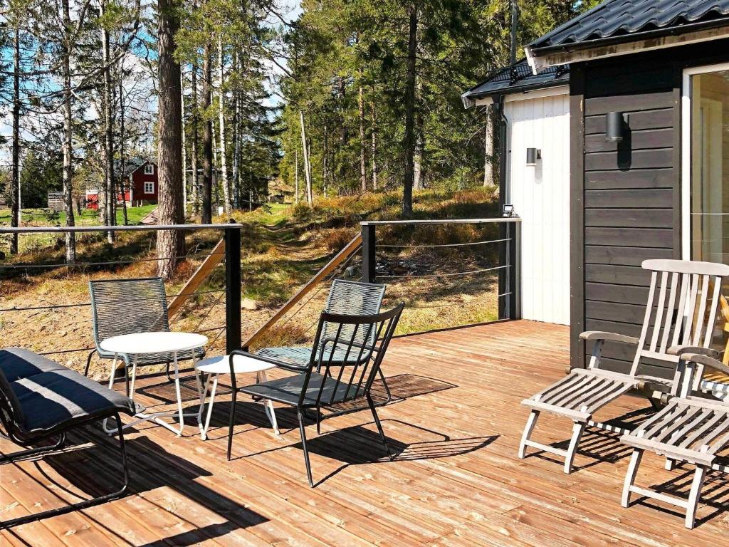 4 chaises et une table sur une terrasse en bois dans l'établissement 4 person holiday home in GARPHYTTAN, à Garphyttan