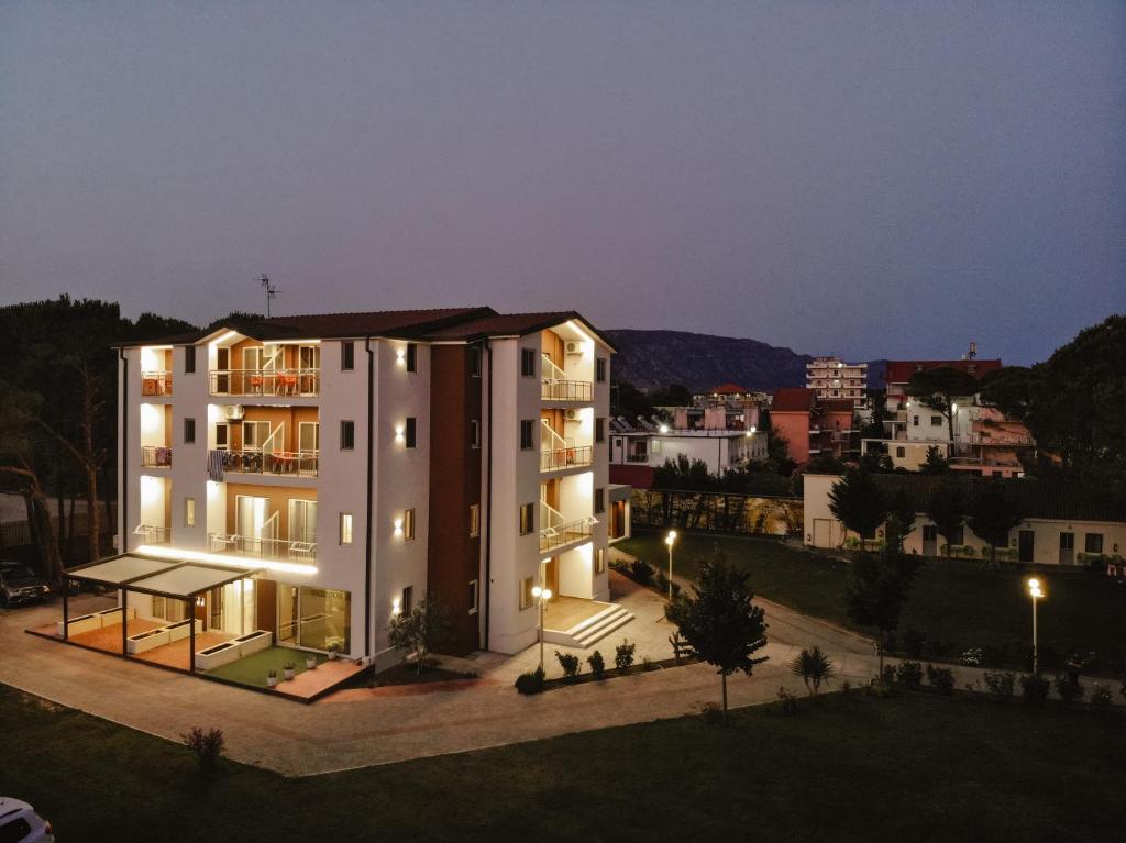 a large white building in a city at night at KOMPLEKSI ROYAL in Velipojë