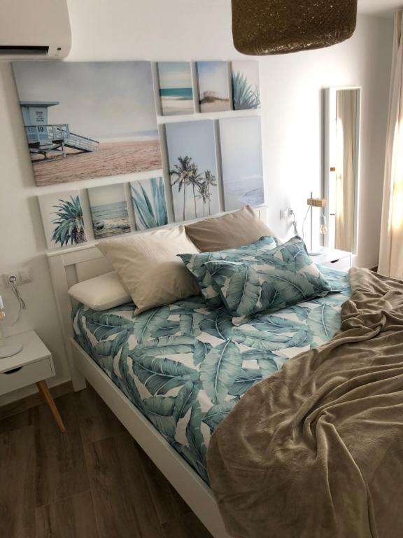 a bedroom with a bed with a picture of a beach at Cerezo's House - Terrace & Jacuzzi in Frigiliana