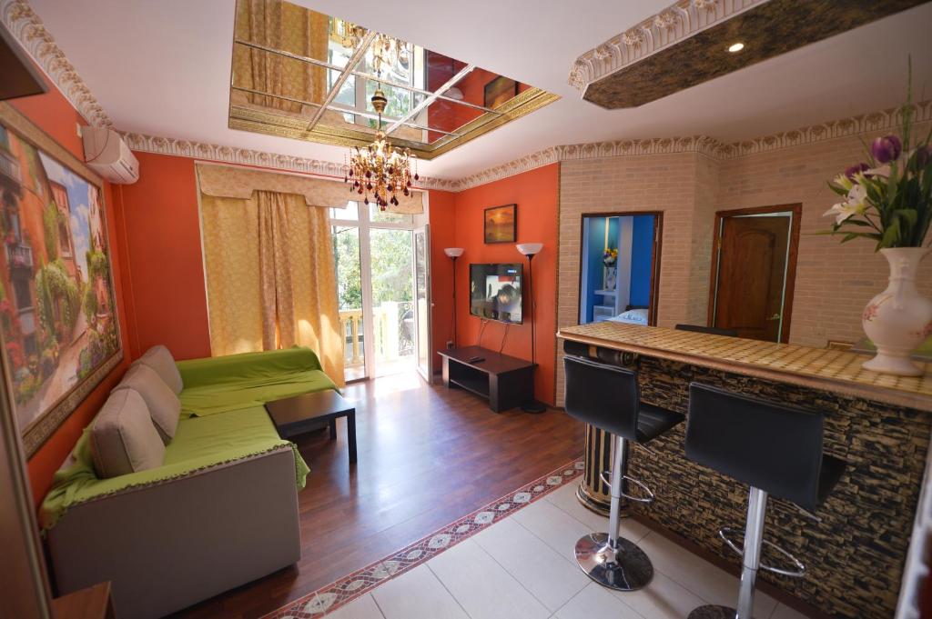 ラザレフスコエにあるMalibu Guest Houseのリビングルーム(緑のソファ、バー付)