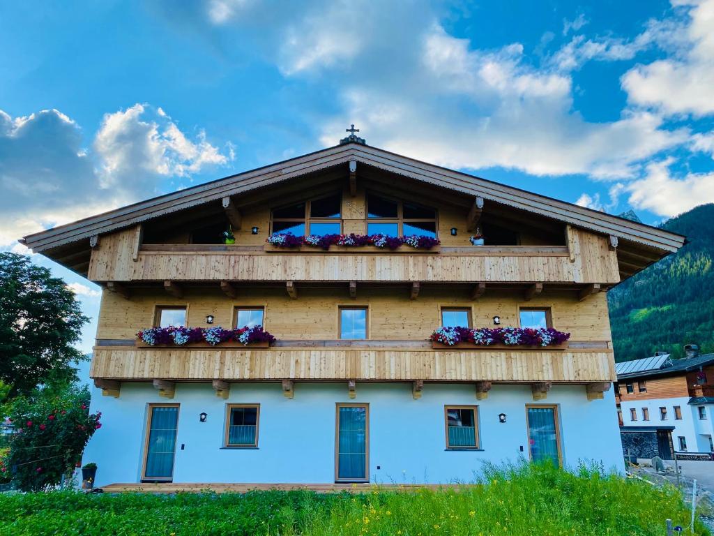 a building with a balcony with flowers on it at Haidacherhof in Eben am Achensee