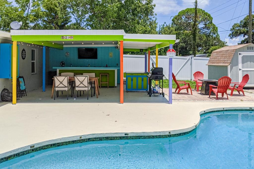 a patio with a table and chairs and a pool at Pinellas Park Cottage in St. Petersburg