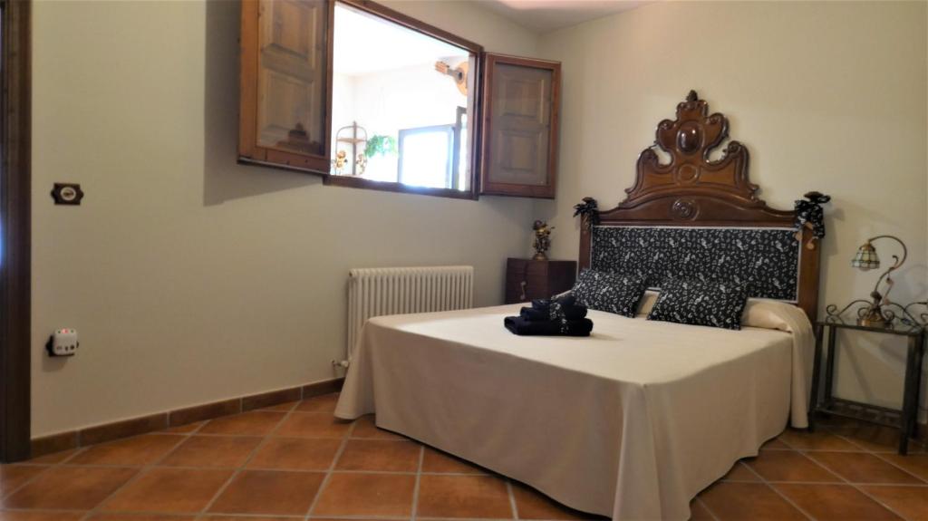 een slaapkamer met een bed in een kamer met een raam bij LA POSADA DEL ISABENA in Roda de Isábena
