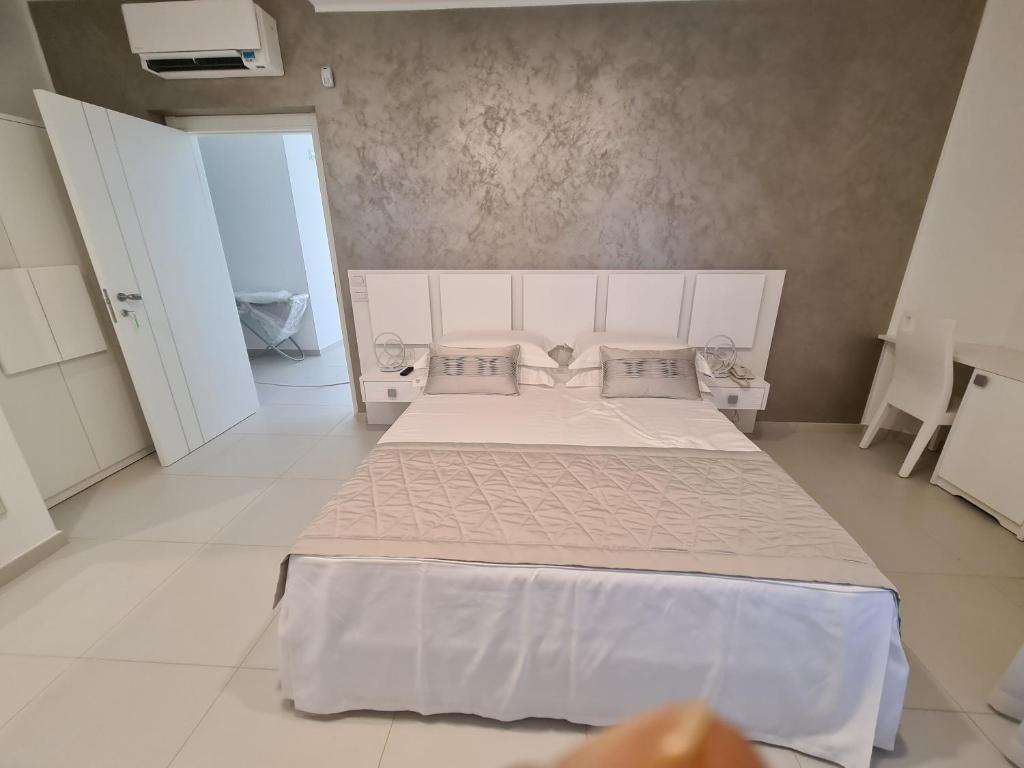 um quarto com uma grande cama branca com almofadas em Baia del Sole Vasto em Vasto