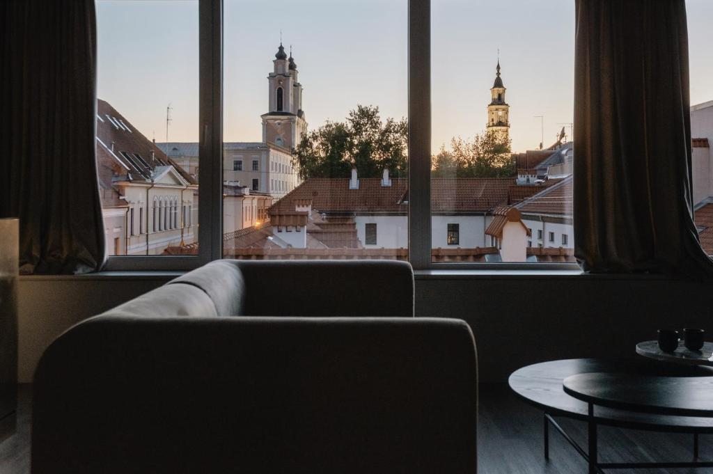 - un salon avec un canapé et une grande fenêtre dans l'établissement Bōheme House, à Kaunas