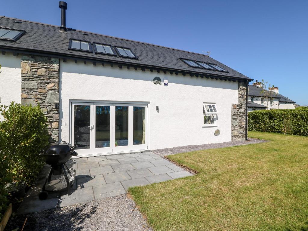 a white house with a grill in a yard at 5 Cleifiog Fawr in Holyhead