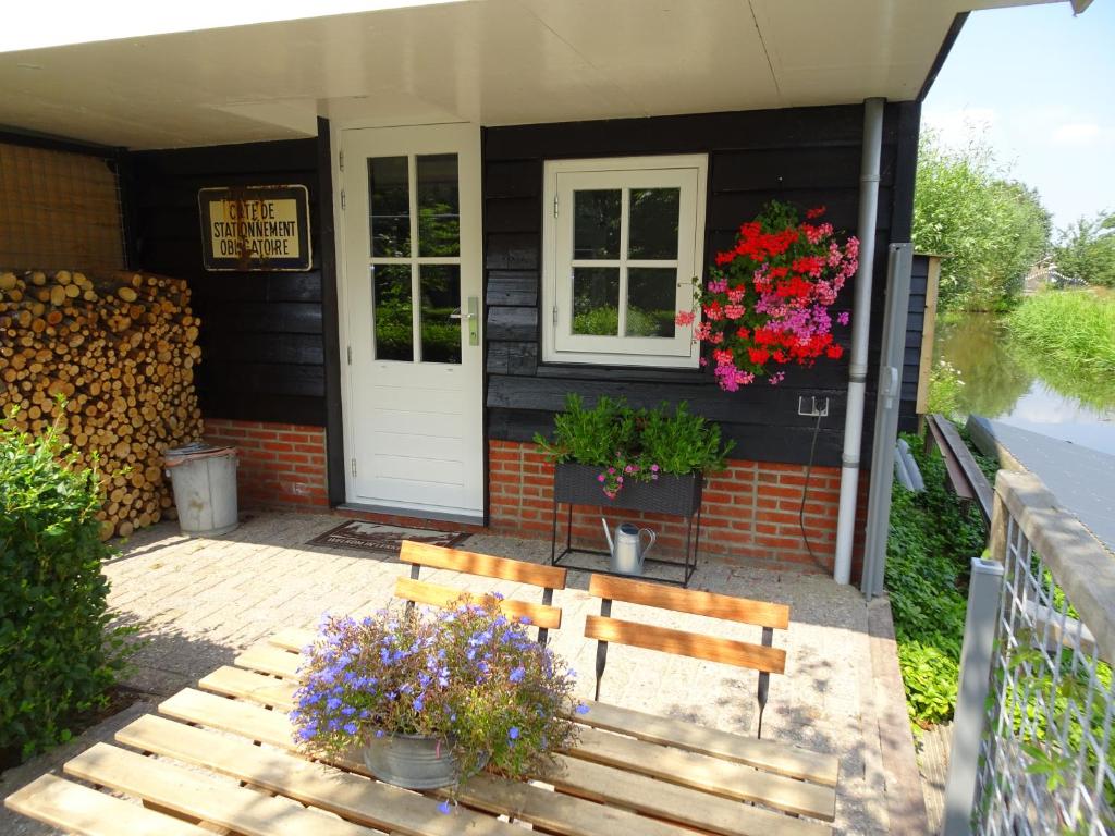 a house with two benches and flowers in front of it at De Kopstoof in Lekkerkerk