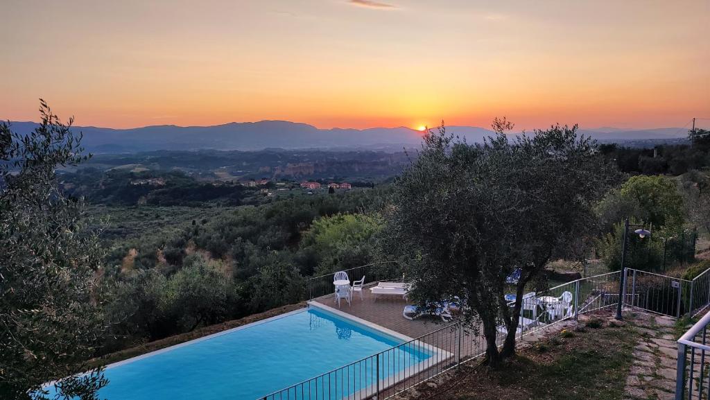 a swimming pool with the sunset in the background at Agriturismo Cafaggio Primo in Loro Ciuffenna