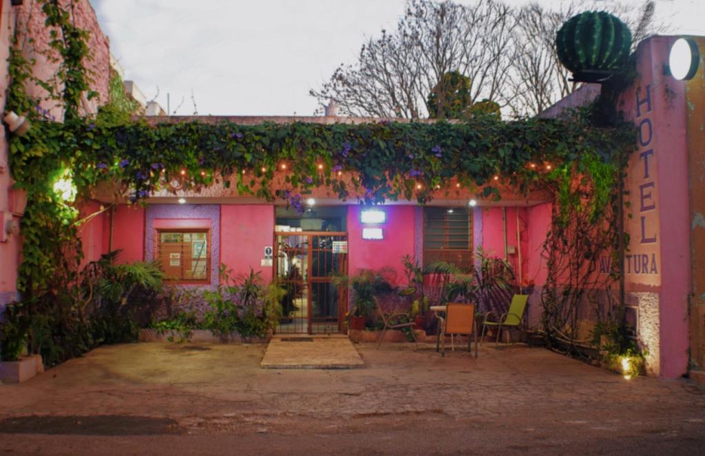 una casa rosa con hiedra a un lado. en Hotel Aventura, en Mérida