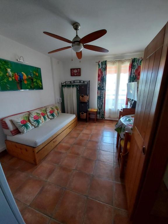 un salon avec un canapé et un ventilateur de plafond dans l'établissement T2-CLIM-FIBRE-GARAGE 2,30 x 4,95 x 1,90 à LA FAVIERE, à Bormes-les-Mimosas