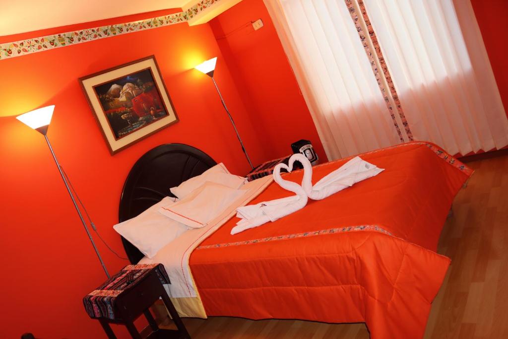 a red bedroom with a bed with a ribbon on it at Colca Andina Inn in Chivay