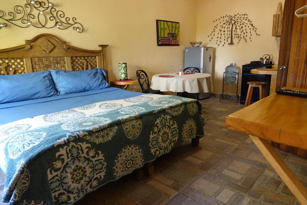 Bungalows Casa Blanca في لا مانزايلا: غرفة نوم بسرير كبير وطاولة