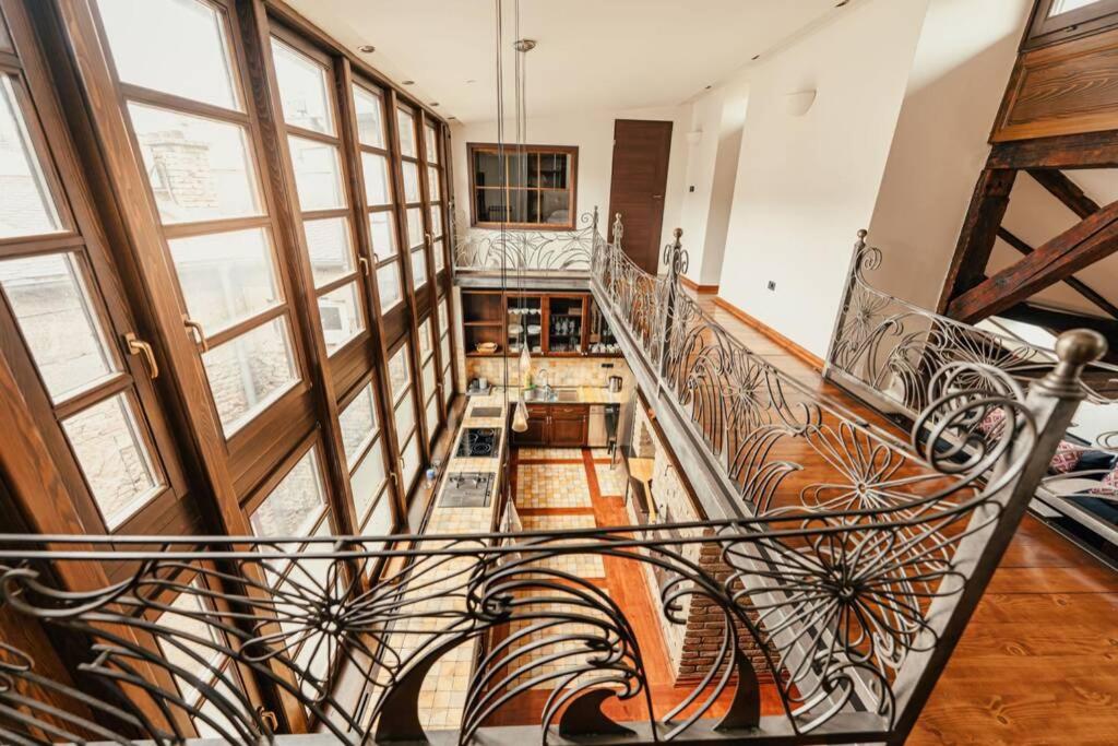 a spiral staircase in a home with wooden floors and windows at Penthouse Sky in Sarajevo