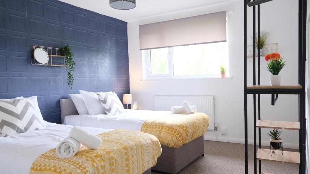 twee bedden in een slaapkamer met blauwe muren bij Unique & Exclusive Contractor and Family House & A1 Road in Grantham