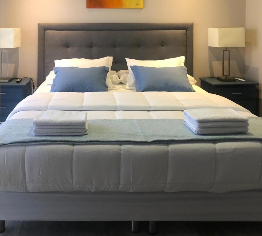 1 cama blanca grande con 2 almohadas en Duplex Charm en Salta