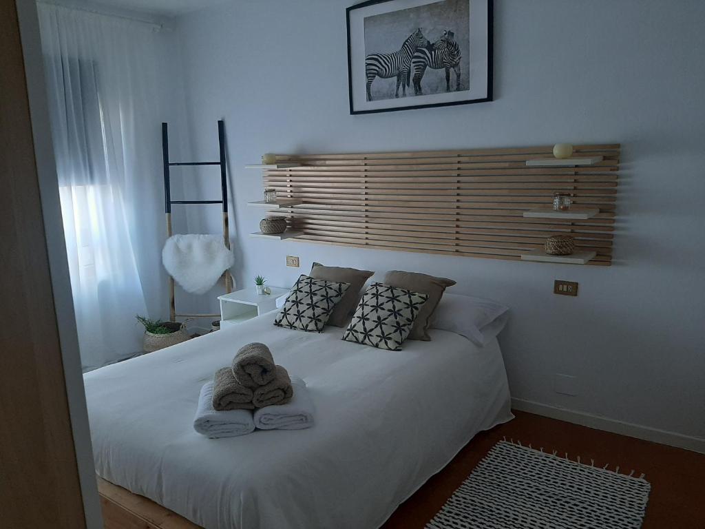 1 dormitorio con 1 cama con toallas en Piso grande con terraza, en Finisterre