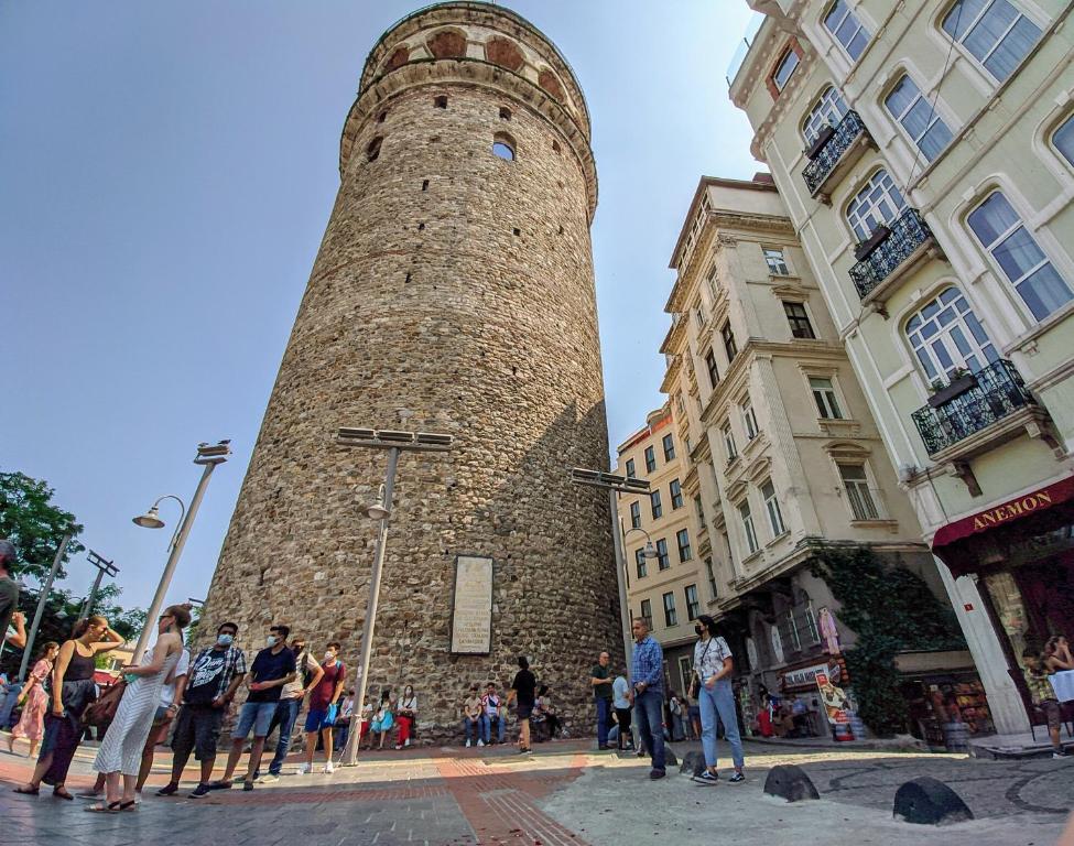 a group of people standing around a tall tower at Galata Suite in Istanbul