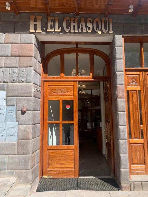 una puerta a un edificio con una señal encima en El Chasqui, en Ollantaytambo