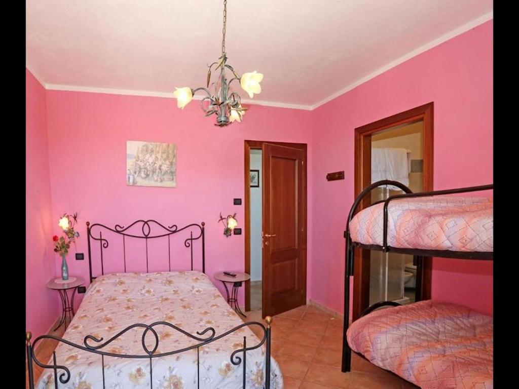 - une chambre avec des murs roses et 2 lits superposés dans l'établissement Agriturismo Al Brich Quadriple room with breakfast, à Albaretto Della Torre 